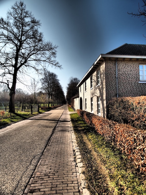 Vertikale Aufnahme eines Gebäudes neben einer Straße unter einem dunklen Himmel