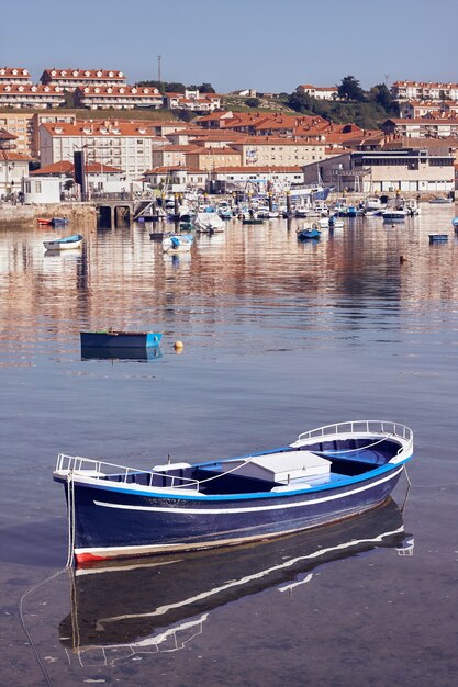 Vertikale Aufnahme eines im Wasser schwimmenden Bootes vor einer Küstenstadt