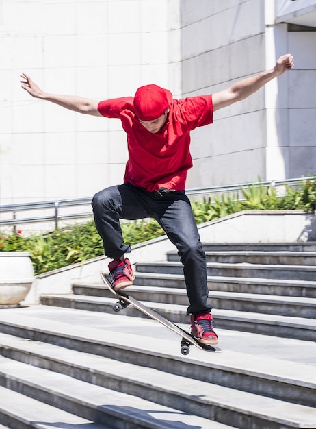 Vertikale aufnahme eines kaukasischen mannes, der auf einem skateboard springt