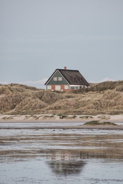 Kostenloses Foto vertikale aufnahme eines kleinen isolierten hauses am ufer des meeres