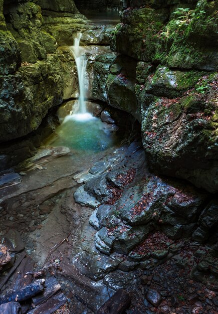 Vertikale Aufnahme eines kleinen Wasserfalls in der felsigen Höhle in der Gemeinde Skrad in Kroatien