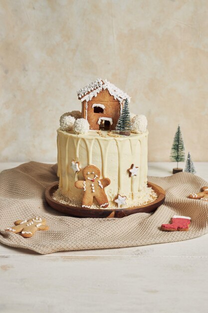 Vertikale Aufnahme eines köstlichen Weihnachtskuchens mit Lebkuchendekorationen und Kokosnuss-Mandelkugeln