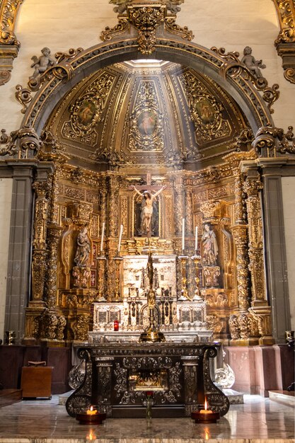 Vertikale Aufnahme eines Kreuzes und eines Altars in der Basilika Unserer Lieben Frau von Guadalupe in Mexiko