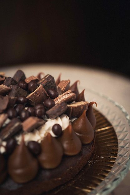 Vertikale Aufnahme eines leckeren Schokoladenkuchens auf einer Glasplatte auf einem Tisch