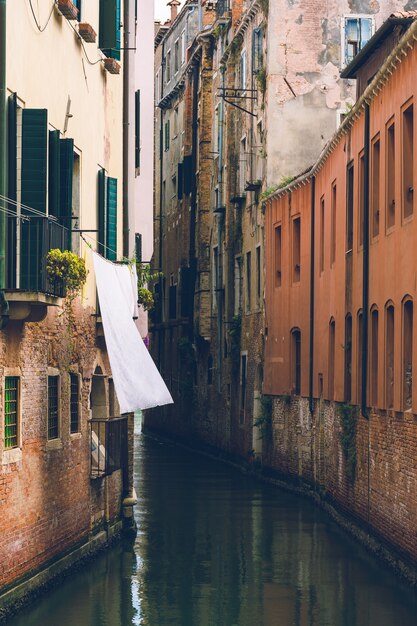 Vertikale Aufnahme eines schmalen Wasserkanals zwischen alten europäischen Gebäuden. Perfekt für eine Tapete.