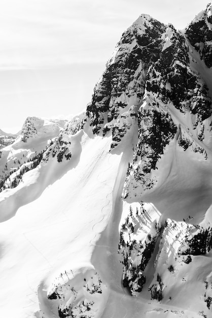 Vertikale Aufnahme eines schneebedeckten Berges mit einem klaren Himmel