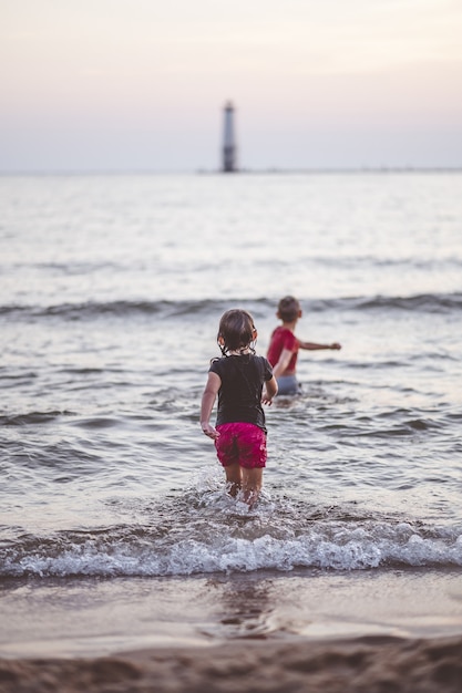 Kostenloses Foto vertikale aufnahme von babys, die in einem meer spielen