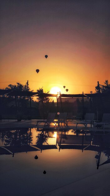 Vertikale Aufnahme von Fallschirmen, die während eines atemberaubenden Sonnenuntergangs fliegen