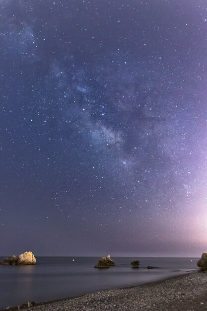 Vertikale Aufnahme von Felsen am Strand von Torre de la Sal in Spanien in einer schönen Nacht