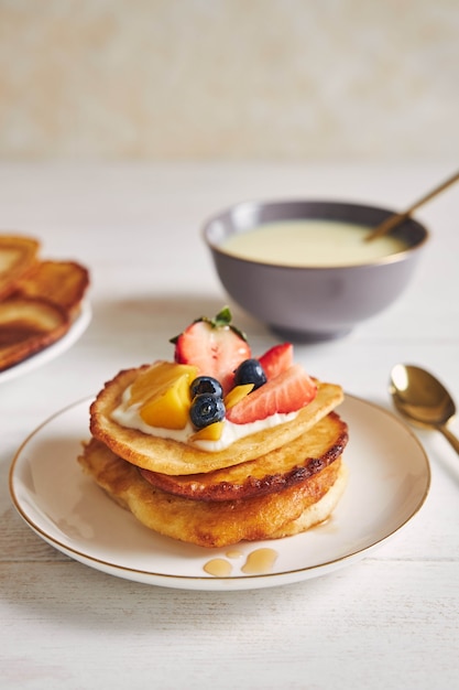 Kostenloses Foto vertikale aufnahme von köstlichen pfannkuchen mit früchten auf der oberseite