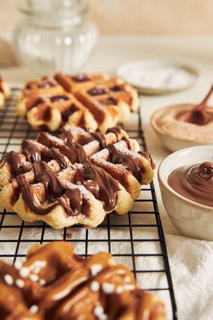 Vertikale Aufnahme von köstlichen Waffeln mit Schokoladendip auf einem weißen Tisch