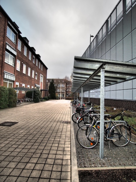 Kostenloses Foto vertikale aufnahme von mehreren fahrrädern, die neben einem gebäude geparkt sind