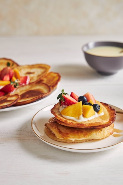 Vertikale Aufnahme von Pfannkuchen mit Früchten auf der Oberseite