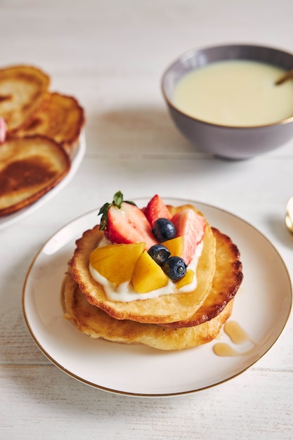 Vertikale Aufnahme von Pfannkuchen mit Früchten auf der Oberseite