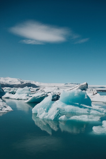 Vertikale Aufnahme von schönen Eisbergen auf dem Ozean, der in Island gefangen genommen wird