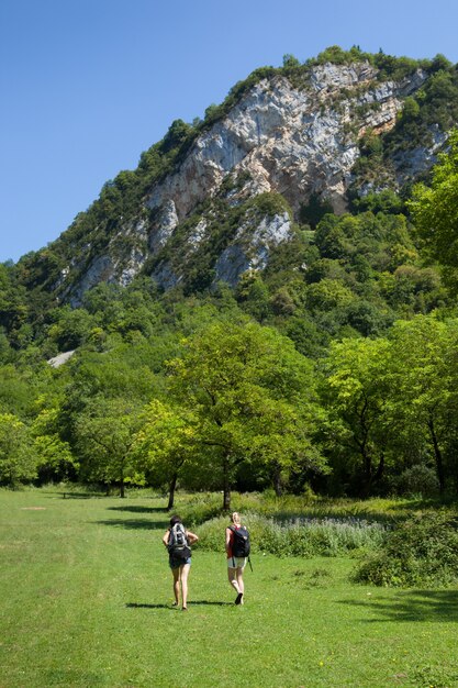 Vertikale Aufnahme von zwei Wandererinnen, die in der grünen Natur von Cerdon, Ain, in Ostfrankreich wandern