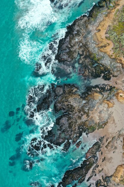 Vertikale Überkopfaufnahme der schönen Küste des Meeres mit blauem sauberem Wasser und Sandstrand