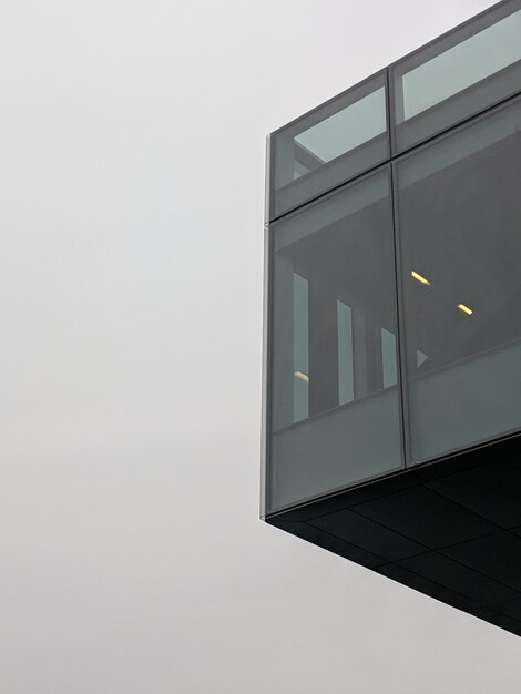 Vertikale Flachwinkelaufnahme eines schwarzen Hochhausgebäudes mit Glasfenstern