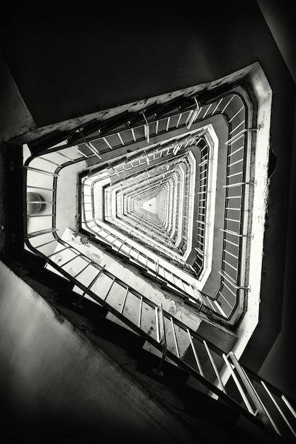 Vertikale Graustufenaufnahme einer Treppe in einem Gebäude