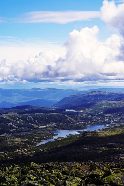 Vertikale Hochwinkelaufnahme der Hügel unter dem bewölkten Himmel in Tuddal Gaustatoppen, Norwegen