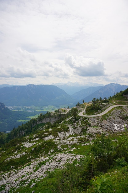 Vertikale Luftaufnahme der österreichischen Alpen unter bewölktem Himmel