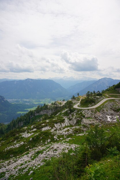 Vertikale Luftaufnahme der österreichischen Alpen unter bewölktem Himmel