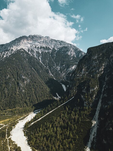 Vertikale Luftaufnahme von grünen Bergen mit weißen Wolken in der Oberfläche