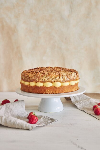 Vertikale Nahaufnahme der köstlichen Vanillecremetorte mit Erdbeeren auf einem weißen Tisch