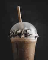 Kostenloses Foto vertikale nahaufnahme einer plastiktasse kalten kaffees mit vanillecreme