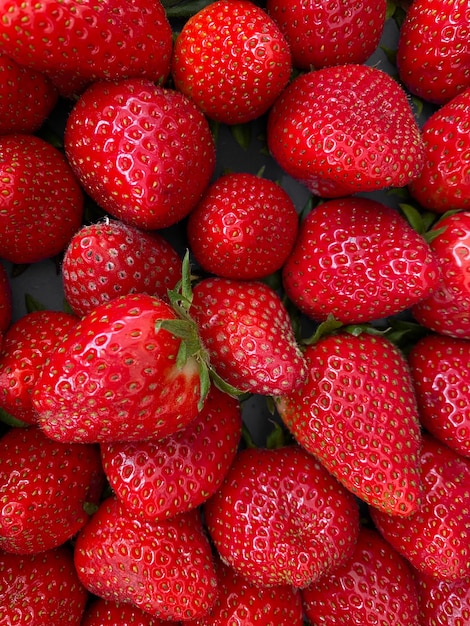 Vertikale Nahaufnahme von leuchtend roten saftigen frischen Erdbeeren