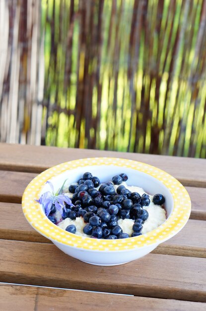 Vertikale Nahaufnahmeaufnahme eines Grießdesserts mit Blaubeeren auf einem Holztisch