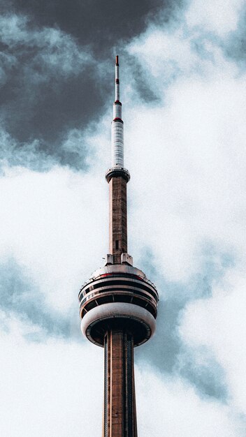 Vertikale schöne Aufnahme der Spitze eines Funkturms unter düsterem bewölktem grauem Himmel