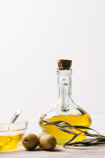 Kostenloses Foto vertikale schussolivenölflasche mit oliven