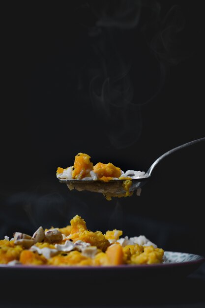 Vertikaler Hochwinkelschuss eines köstlichen heißen Gerichts mit Reis, Huhn und gelber Soße
