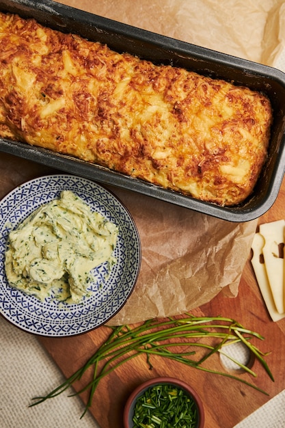 Kostenloses Foto vertikaler schuss brot mit käsekräuterbutter auf einem holz