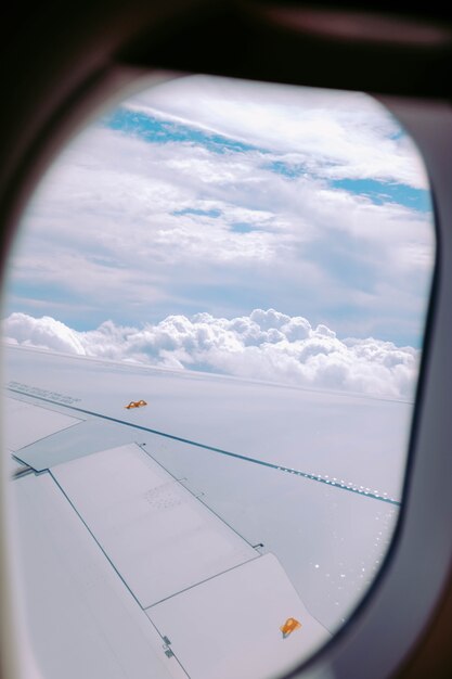 Vertikaler Schuss der Wolken, die von einem Flugzeugfenster erfasst werden