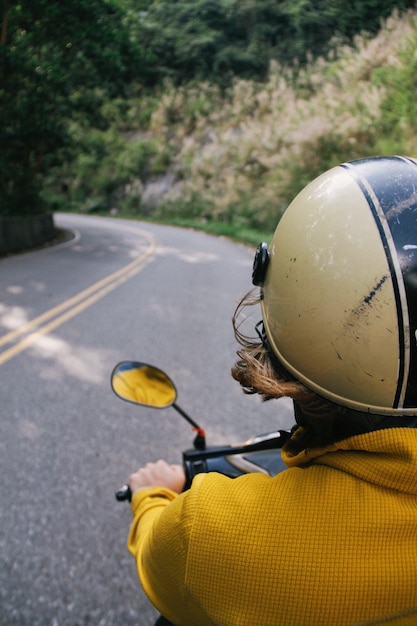 Kostenloses Foto vertikaler schuss einer person mit einem helm, der ein motorrad reitet