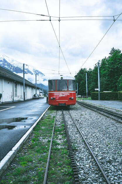 Vertikaler Schuss einer roten Straßenbahn, die sich durch die Schienen vorwärts bewegt