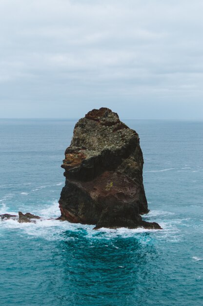 Vertikaler Schuss eines großen Steins in der Mitte des Ozeans, der in Madeira, Portugal gefangen genommen wird