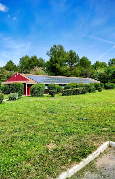 Vertikaler Schuss eines kleinen Hauses mit Sonnenkollektoren im grünen Feld in den Kanarischen Inseln