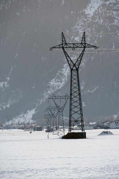 Vertikaler Schuss eines Sendemastes mit einer schneebedeckten Oberfläche während des Winters