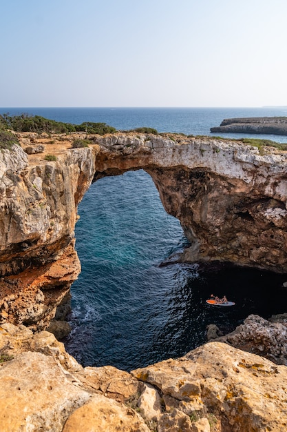 Vertikaler Schuss eines Steinbogens über Wasser in Mallorca, Spanien