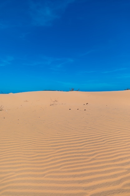 Vertikales Bild der schönen Sanddünen von Mui Ne, Vientam unter einem klaren blauen Himmel
