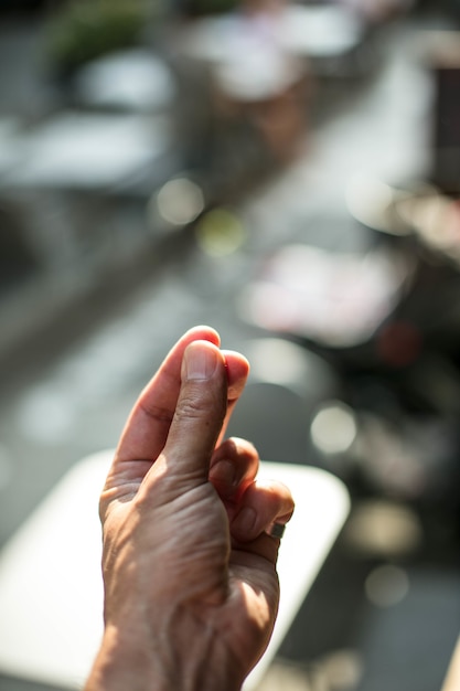 Vertikales Bild des Schnappens von Fingern unter den Lichtern mit einem verschwommenen Hintergrund und einem Bokeh-Effekt