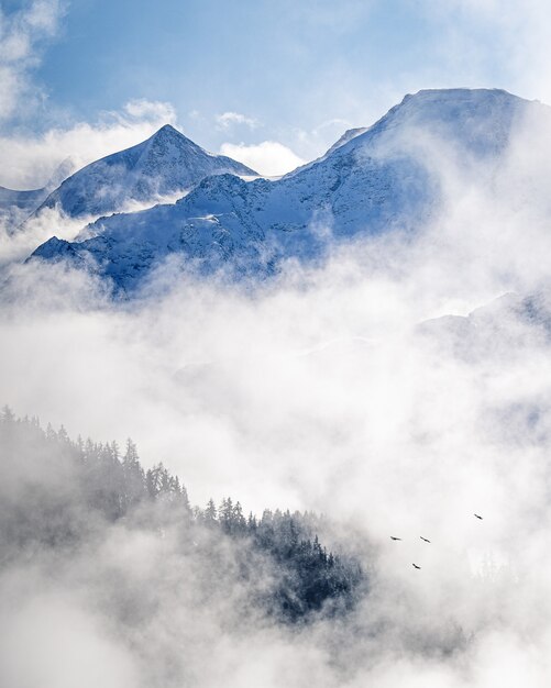 Vertikales Bild einer szenischen nebligen Landschaft auf alpinen Bergen