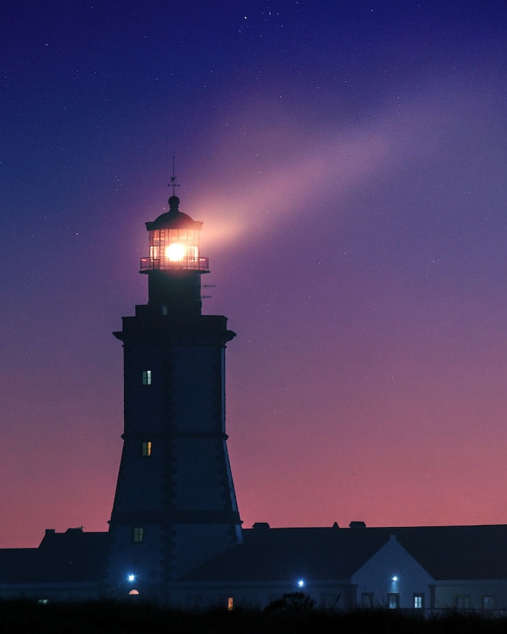Kostenlose Foto vertikales bild eines leuchtturms unter einem sternenhimmel am abend