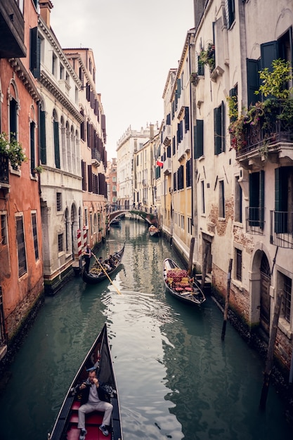 Vertikales Bild von Gondeln auf dem großen Kanal zwischen bunten Gebäuden in Venedig, Italien