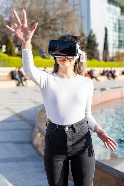 Vertikales Foto einer Virtual-Reality-Brille einer jungen Dame, die ihre Hand hochhält Foto in hoher Qualität