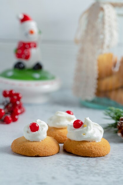 Vertikales Foto von cremigen Weihnachtsplätzchen auf grauer Oberfläche.