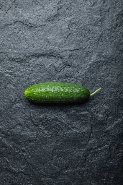 Vertikales Foto von frischen Bio-Gurken auf schwarzem Hintergrund.